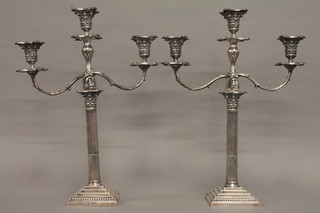 A handsome pair of Edwardian silver 3 light candelabrum, raised  on square stepped bases with fluted and reeded columns with  Corinthian capitals, the bases marked London 1900, the twin  light branches marked London 1898 and the centre section  marked Sheffield 1900  ILLUSTRATED FRONT  COVER