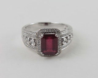 A 14ct white gold dress ring set a rectangular cushion cut ruby  approx 4ct supported by diamonds approx 1ct