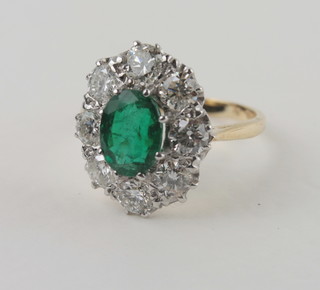 A lady's 18ct yellow gold dress ring set an oval cut emerald surrounded by numerous diamonds approx 2/1.75ct