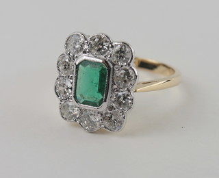 A lady's 18ct yellow gold dress ring set a rectangular cut emerald surrounded by diamonds, approx. 1.45ct/0.90ct