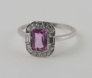 A lady's 18ct white gold dress ring set a rectangular cut pink sapphire supported by diamonds