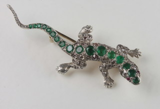 A gold brooch in the form of a lizard, the body set emeralds and diamonds