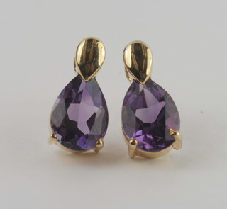 A pair of gold earrings set amethysts