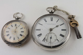 An open faced pocket watch by Langdon Davis contained in a  silver case and a lady's silver cased fob watch