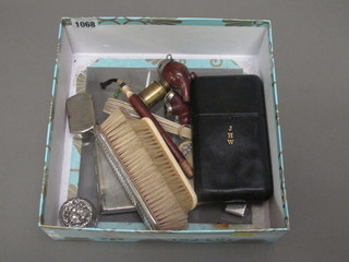 A black leather cigar case, a silver backed clothes brush, do. ivory and various curios
