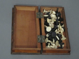 A travelling black and white ivory chess set complete with  folding board