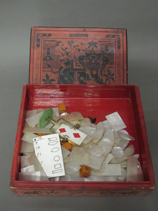 A rectangular Eastern lacquered box containing a collection of  carved mother of pearl game counters
