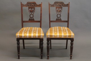 A set of 4 Edwardian carved walnut slat back dining chairs with upholstered seats, raised on turned supports