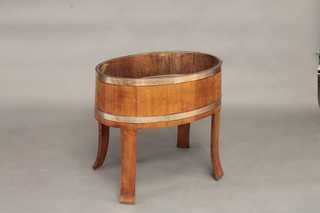 An oval coopered mahogany and brass banded wine cooler/planter 26"