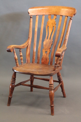 An elm stick and rail back Windsor kitchen carver chair, raised  on turned supports