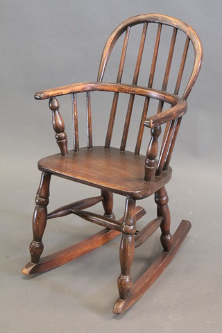 A childs elm stick and rail back rocking chair
