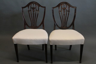 A set of 4 Hepplewhite style mahogany shield back dining chairs  with upholstered seats, raised on square tapering supports