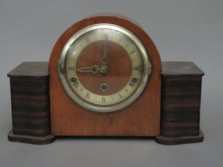 An Art Deco mantel clock with arch shaped silvered dial and Arabic numerals contained in an oak case 12"