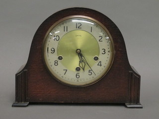 A 1930's Smiths 8 day chiming mantel clock with silvered chaptering and Arabic numerals, contained in an oak arch shaped  case