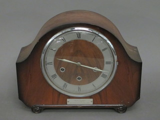 A Smiths 8 day chiming mantel clock with silvered chapter ring and Roman numerals, contained in a walnut arch shaped case