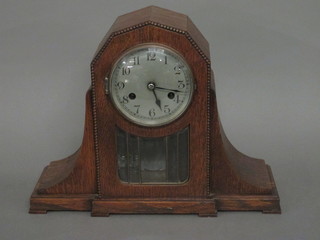 A 1920's striking mantel clock with silvered dial and Arabic  numerals contained in an oak case