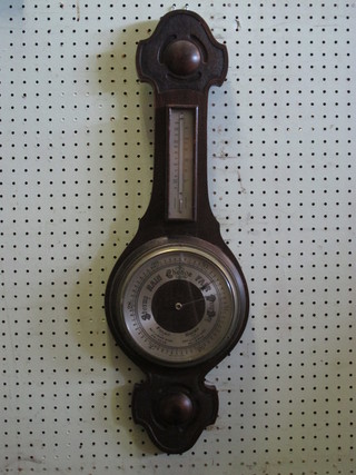 An aneroid barometer and thermometer with silvered dial  contained in an wheel case