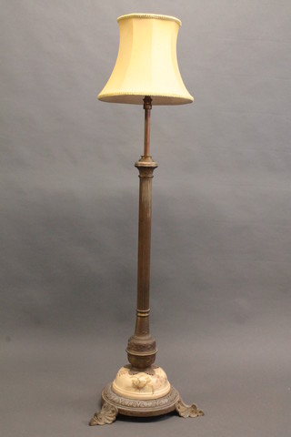 A brass reeded adjustable oil lamp raised on a reeded column