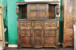 A carved oak court cupboard, the upper section supported by carved bulbous supports, the base fitted 1 short and 2 long  drawers above a double cupboard 49"