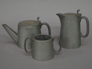 A circular 3 piece English planished pewter tea service with teapot, hotwater jug and twin handled sugar bowl