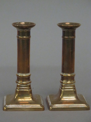 A pair of brass candlesticks raised on square bases 6"