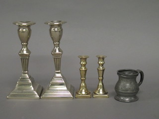 A pair of 19th Century brass candlesticks with ejectors 7", a pair  of taper sticks 4" and a pewter spirit measure