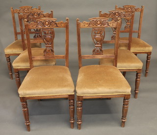 A set of 6 Edwardian carved walnut dining chairs with vase shaped slat backs and upholstered seats, raised on turned supports