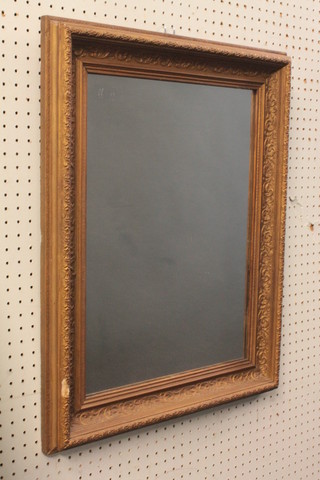 A rectangular plate mirror contained in a decorative gilt frame 25"