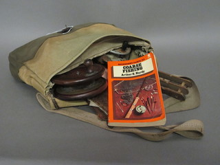 A Hardy's fibre and leather fishing bag containing a wooden centre pin fishing reel, an aluminium centre pin fishing reel and a  small collection of fishing tackle