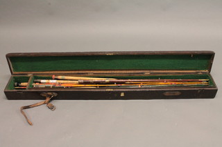 A wooden box containing a collection of various fishing rods