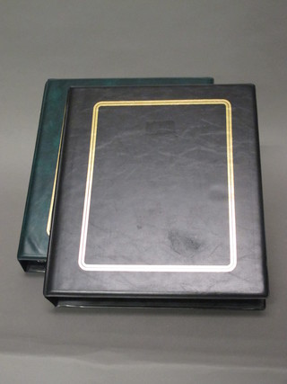 A green loose leaf stamp album and a black loose leaf stamp  album
