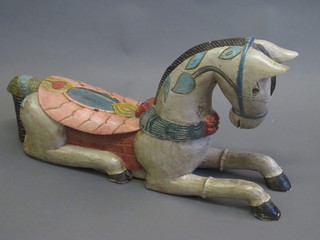 A carved and painted wooden figure of a reclining horse 36"