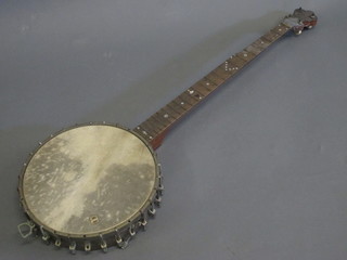 A 4 stringed banjo marked Popular with 11" circular drum