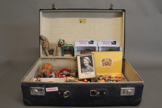 A blue suitcase containing a collection of toys etc