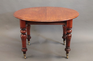A Victorian mahogany circular extending dining table with 1 extra leaf, raised on turned supports 41"