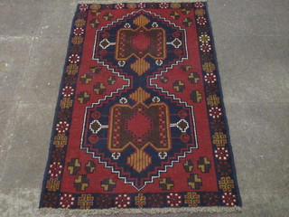 A Persian red and black ground Belouch rug 56" x 35"