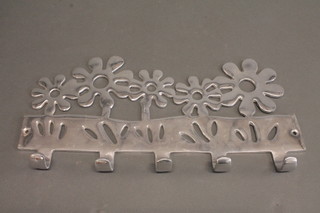 A pierced metal coat rack decorated flowers 15"