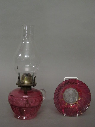 A Victorian cranberry glass oil lamp reservoir with clear glass  handle 3" complete with shade and a circular red glass bowl