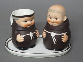 A Goebel 2 piece jug and bowl condiment set in the form of 2  standing Monks, raised on a tray