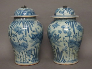 A pair of Oriental blue and white urns and covers with floral decoration 17"
