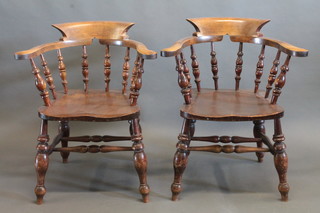 A pair of elm captain's chairs, raised on turned supports
