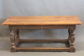 An oak refectory style dining table, raised on turned and block supports with wooden box stretcher 72"