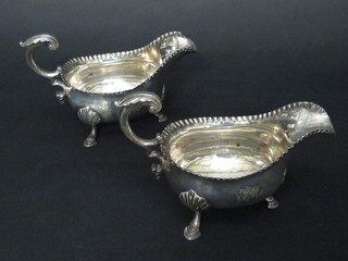 A handsome pair of George III silver sauce boats with wavy  borders and C scroll handles, raised on hoof supports, London  1764, 20 1/2 ozs, both f and r, 1 with tear and repair,   ILLUSTRATED