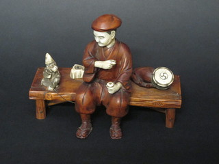 An Oriental hardwood and ivory figure of a seated gentleman  with monkey, the base with seal mark 8"   ILLUSTRATED