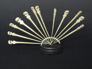 A set of 12 carved ivory cocktail sticks, raised on a stand