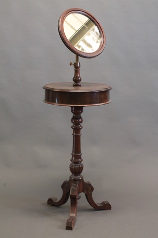 A Victorian mahogany shaving stand with adjustable circular plate mirror, the base fitted 2 compartments enclosed by hinged  lids, raised on a pillar and tripod base