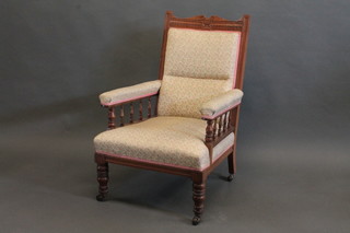 A Victorian carved walnut armchair with upholstered seat and back, raised on turned supports