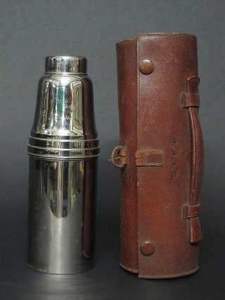 A 1930's silver plated cocktail shaker, the interior fitted 2 glass bottles, 1 with chip to rim, missing 1 bottle, complete with lemon  squeezer and 4 beakers, all contained in a leather carrying case