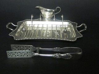 A silver plated twin handled asparagus dish complete with sauce boat and servers