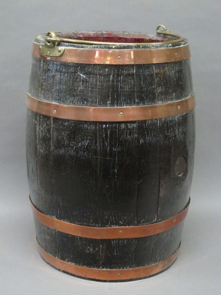 An oak coopered barrel with brass swing handle